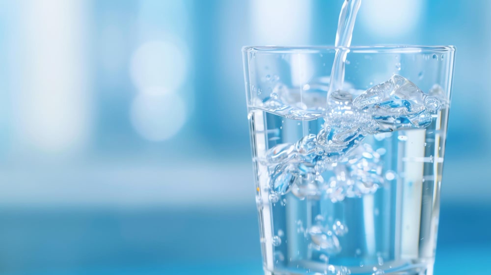 Fresh clean water being poured into a glass with crystal clarity