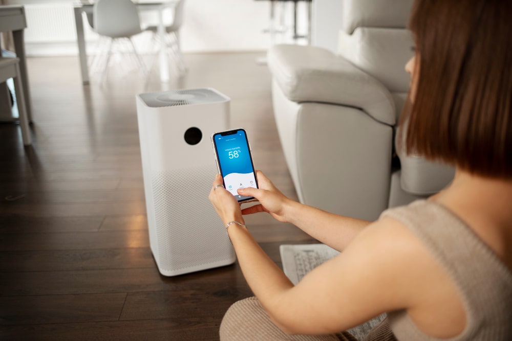 Woman using smartphone to control AI air purifier in modern home